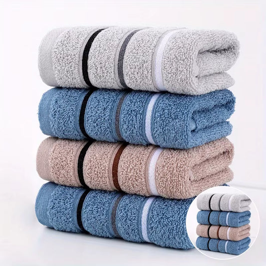Stack of folded towels in grey, blue, and beige colors with decorative bands on a white background.