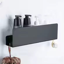 Black wall-mounted shelf with soap dispensers on a marble bathroom wall.