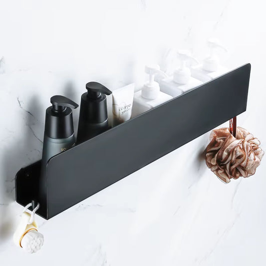 Black shelf with bathroom products on a marble wall